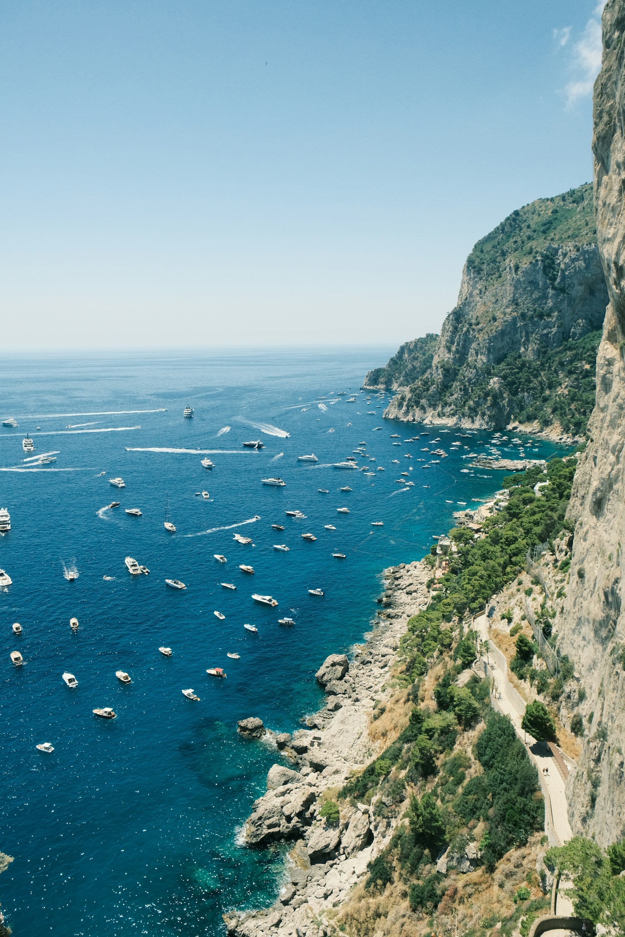 Boats and turquoise water beside the cliffs of Capri